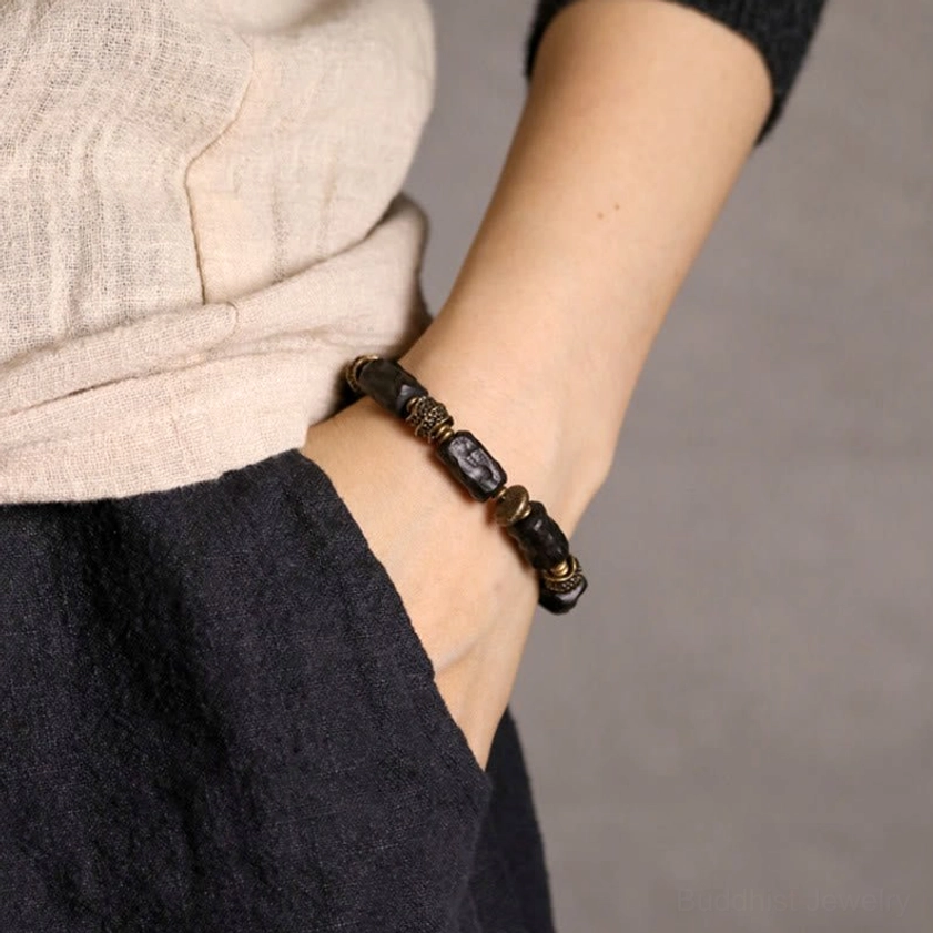Ebony wood copper Buddhist bracelet worn on wrist with casual clothing