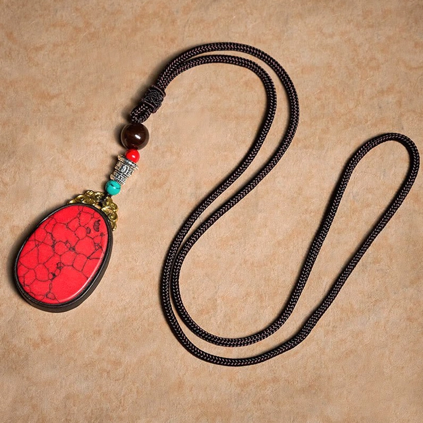 Close-up detail of ebony wood frame and natural cracked stone pendant craftsmanship for Buddhist necklace
