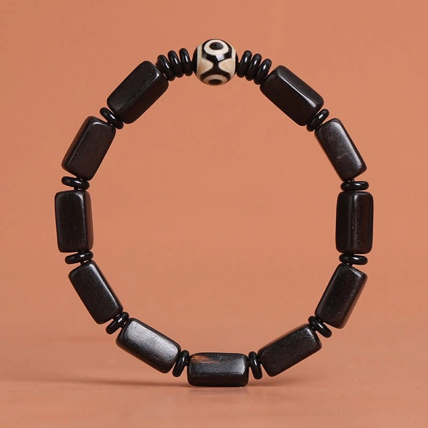 Ebony wood Dzi bead bracelet with two-eye design showing natural dark wood tones and hand-painted Dzi accent