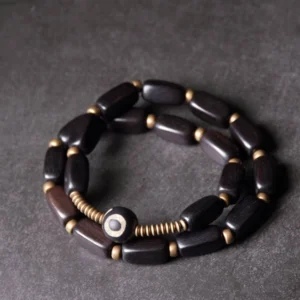 Ebony wood dzi bead double wrap bracelet with nine-eye pattern flat lay top view