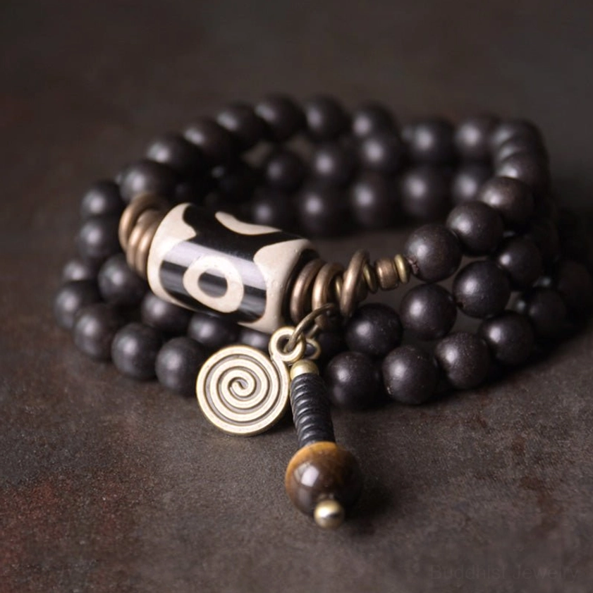 Ebony wood dzi bead copper protection bracelet flat lay on dark rustic surface showing full design with bronze accents