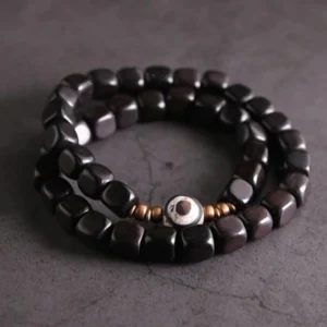 Ebony wood and hand-painted nine-eye dzi bead couple bracelet with copper spacers, top-down flat lay view