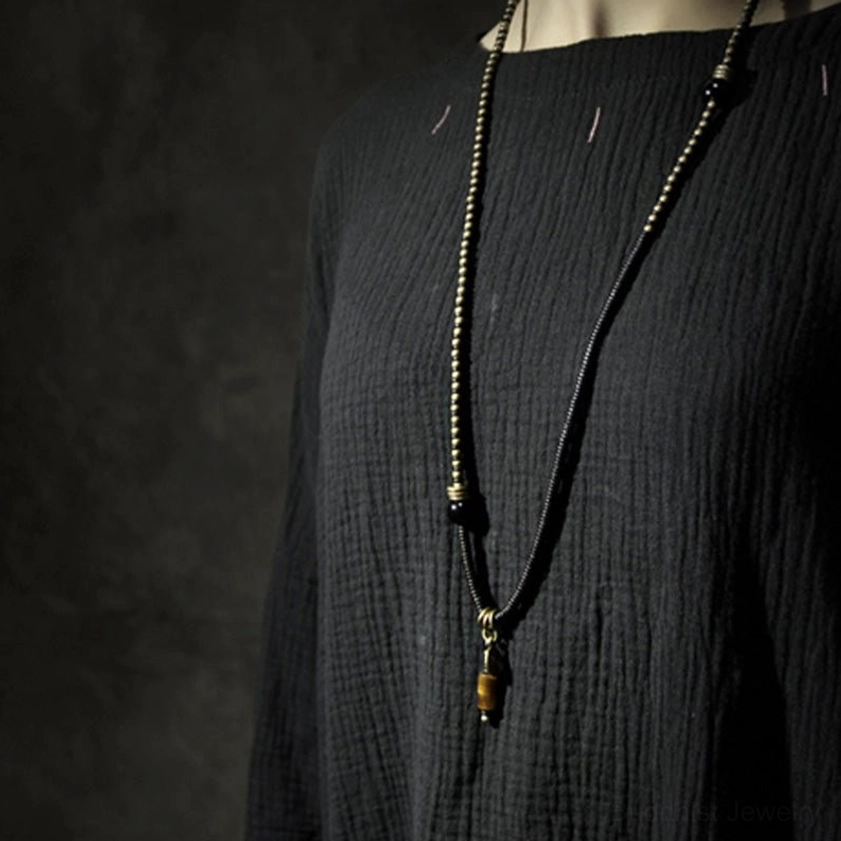 Long double-strand ebony wood dzi bead necklace pendant worn on mannequin showing nine-eye dzi bead and tiger eye drop