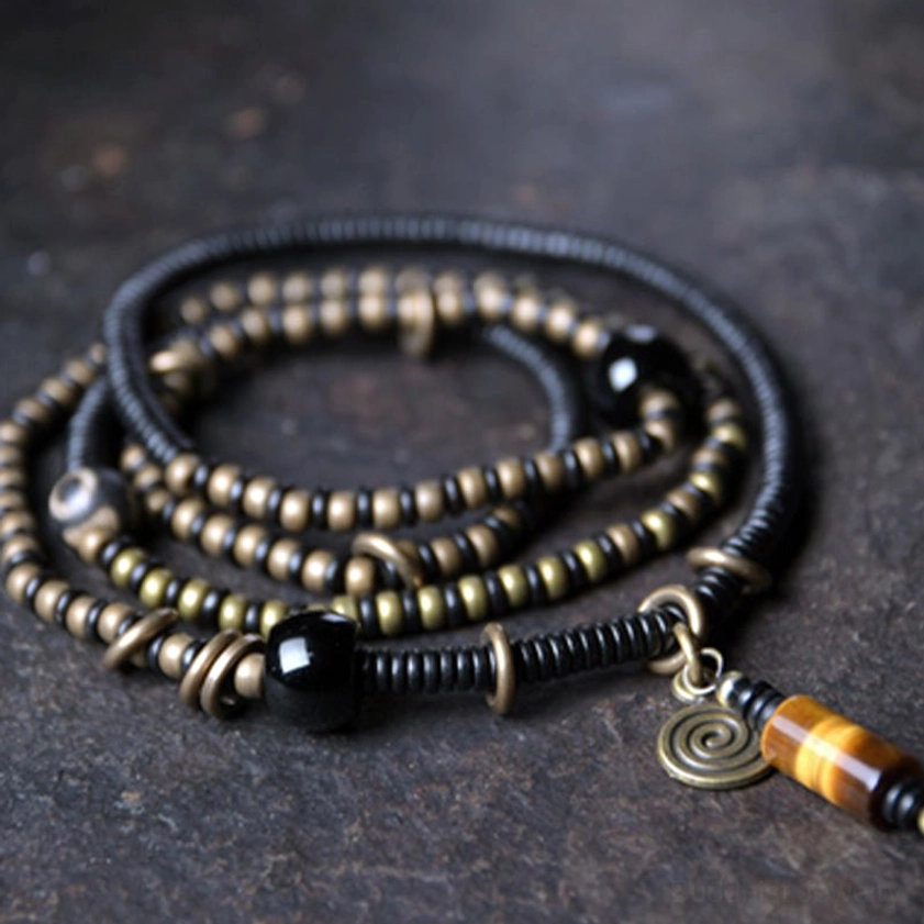 Ebony wood dzi bead copper peace bracelet necklace pendant flat lay overhead view showing multi-layer beaded design with nine-eye dzi bead