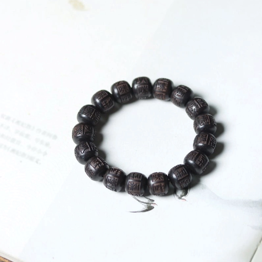Full circular bracelet laid flat on white background displaying all engraved wooden beads clearly