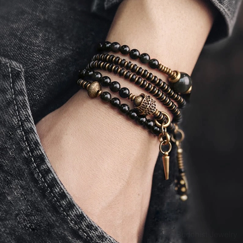 Ebony wood beads detail on Buddhist protection bracelet showing natural wood texture and grain with black obsidian spacing