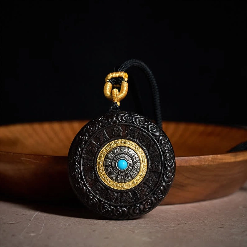 Back view of ebony wood Buddhist pendant showing carved mantra disc with turquoise stone center