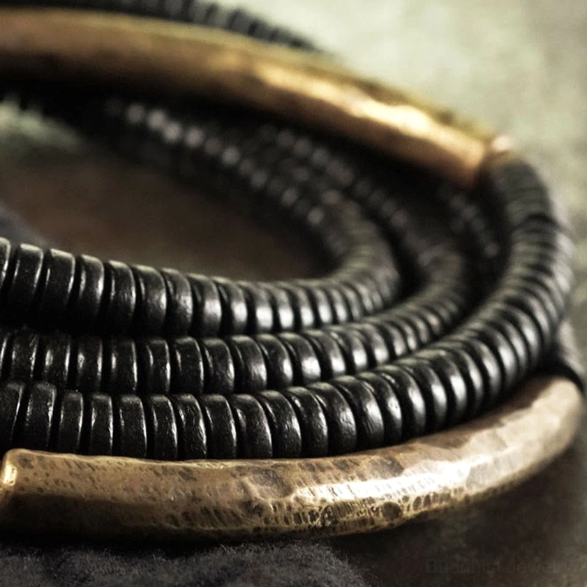 Multi-strand ebony wood and brass Buddhist bracelet showing layered composition