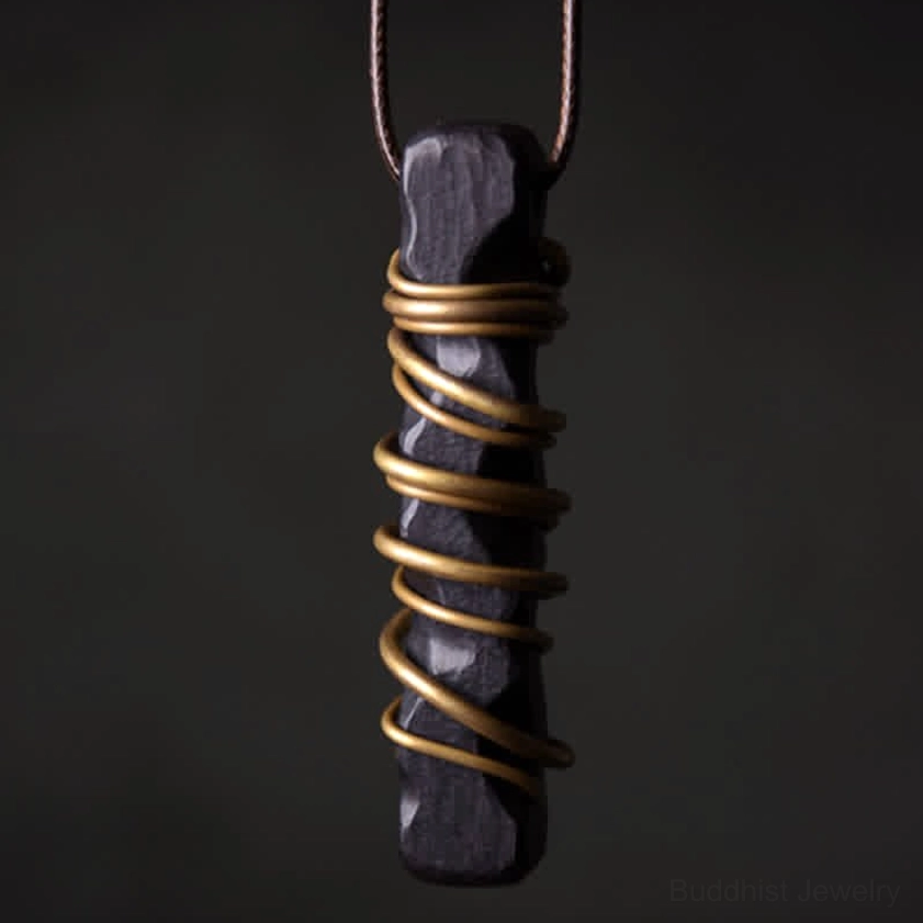 Ebony wood zen circle brass pendant necklace front close-up view with intricate brass wire wrapping detail
