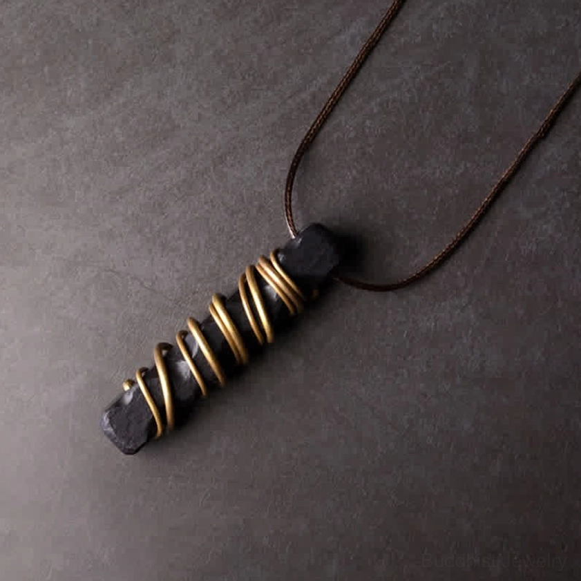 Ebony wood brass necklace pendant side angle view showing natural wood grain and wax cord