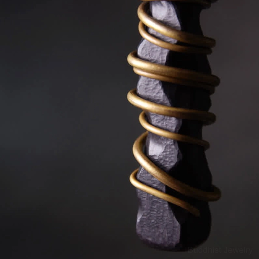 Ebony wood zen circle pendant side close-up highlighting rough wood texture and brass coils