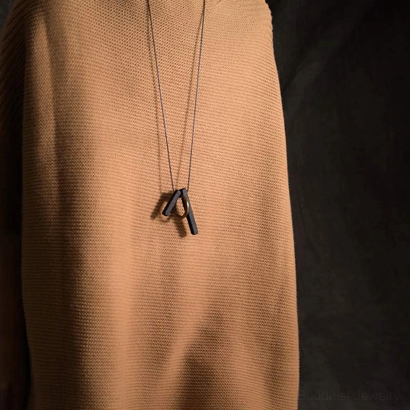 Ebony wood Zen circle Buddhist necklace worn on tan fabric showing everyday style