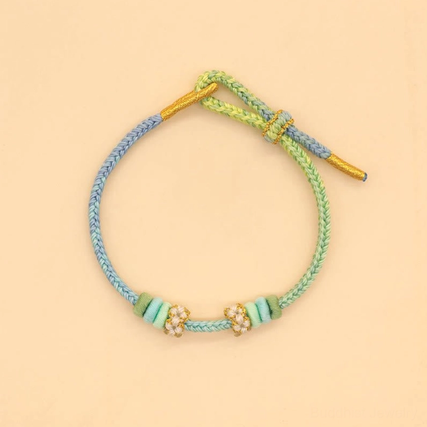 Blue-green gradient eight-thread peace knot bracelet with small beaded accents on neutral background