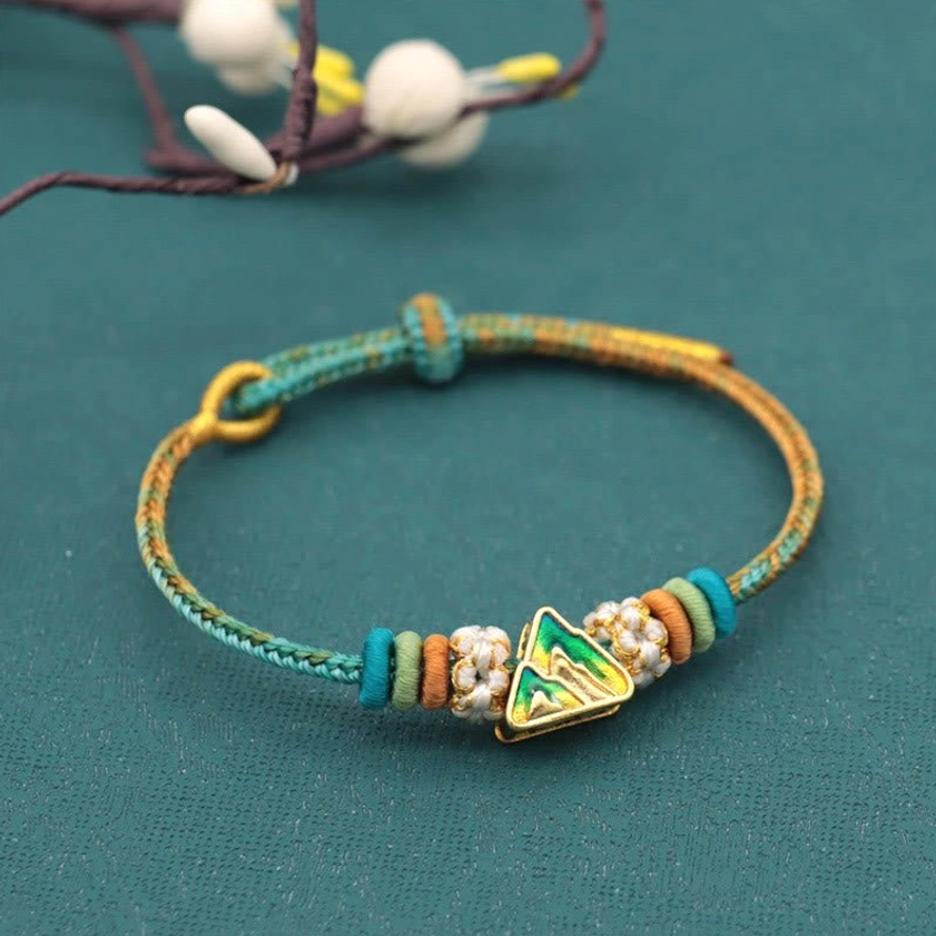 Mountain-inspired eight-thread peace knot bracelet in earth tones with traditional knot artistry
