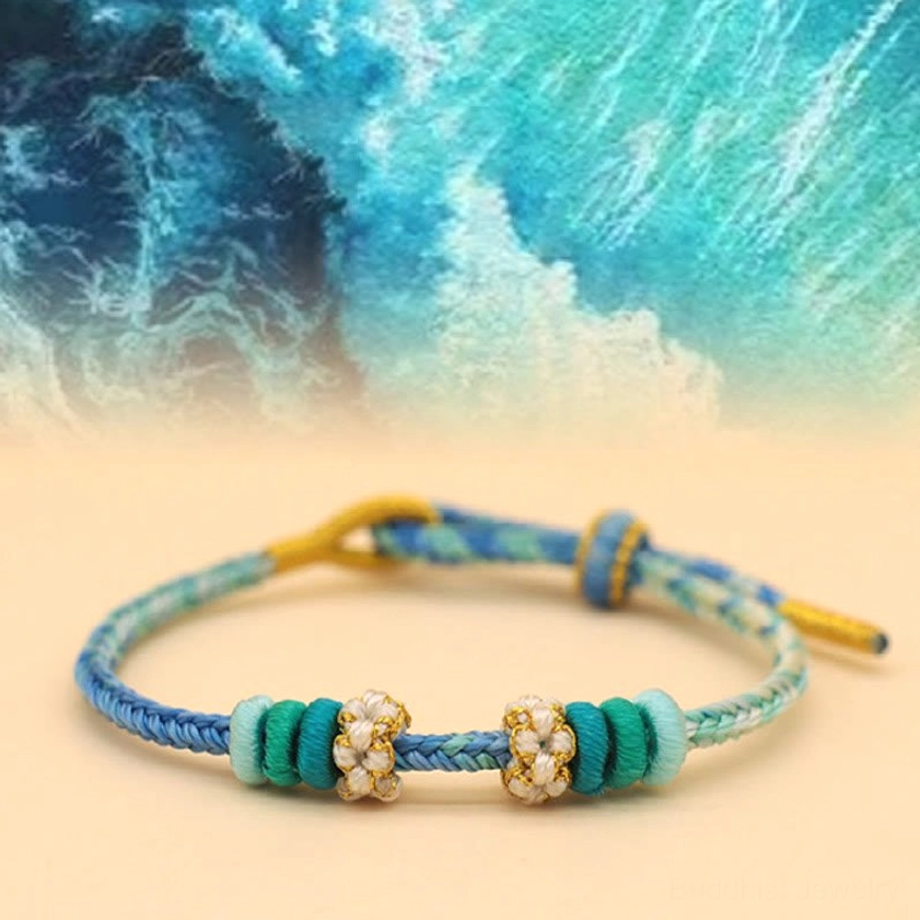 Blue and green Buddhist string bracelet with eight-thread peace knot and peach blossom charm detail