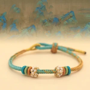 Multicolor eight-thread peace knot braided bracelet with peach blossom charm on Chinese landscape background
