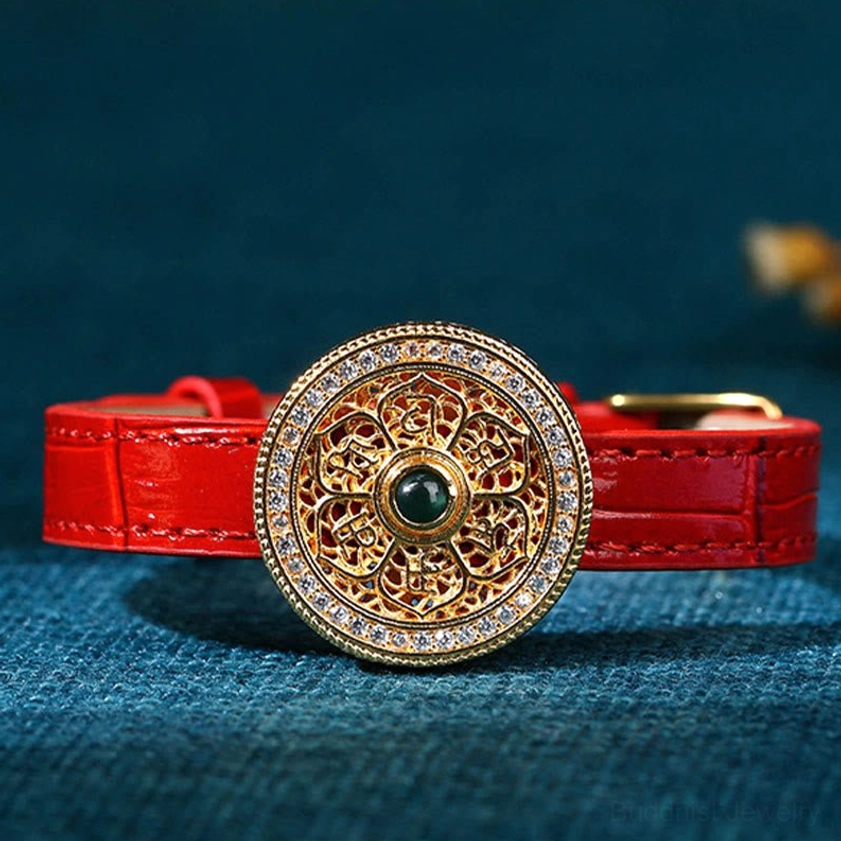 Front view of handmade Eight Treasures Compass jade bracelet with intricate filigree gold charm and dark green gem center