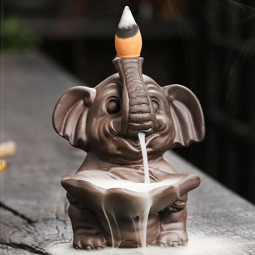 Front eye-level view of handmade purple clay elephant incense fountain with intact cone and clear smoke cascade