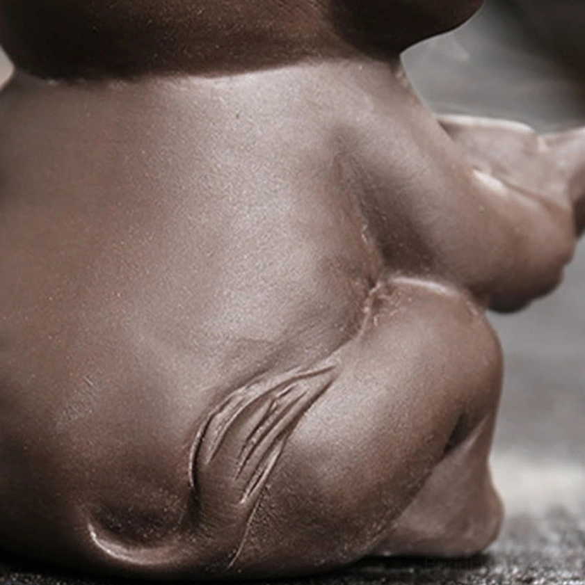 Purple clay elephant backflow incense fountain in use with flowing smoke on decorative wooden table