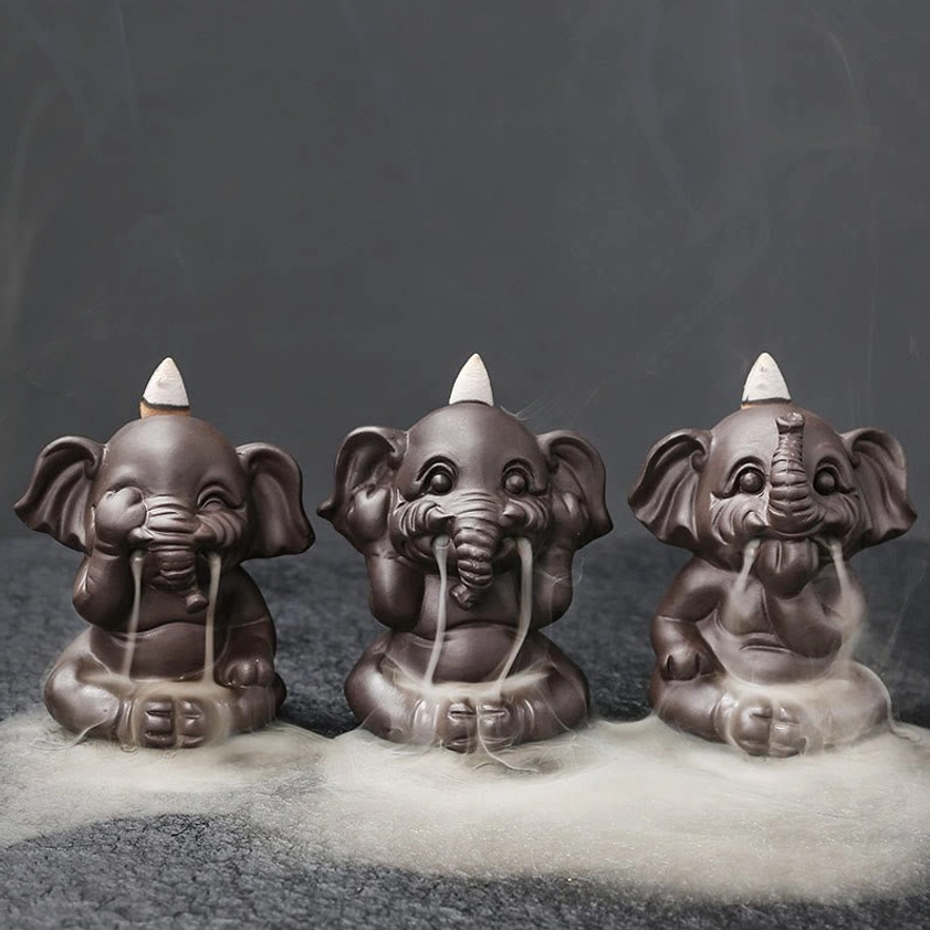 Three cartoon-style elephant backflow incense holders in matte purple clay with flowing smoke, front flat view premium ceramic finish
