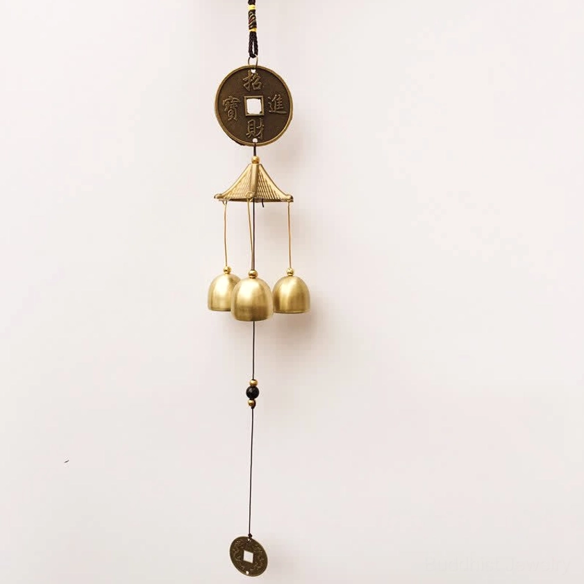 Elephant and Bagua brass wind chime displayed with natural lighting showing bronze patina and symbol details
