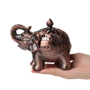 Handcrafted elephant bronze incense burner with floral carved details, held in hand showing side profile and removable dome lid