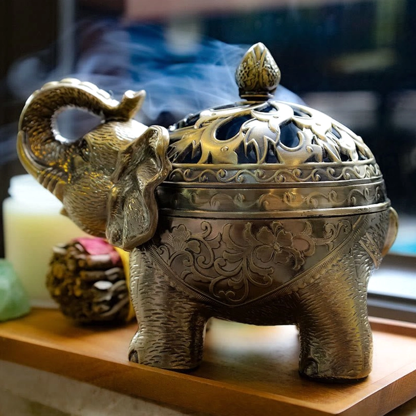Elephant incense holder back view in home setting with rising incense smoke, tabletop meditation altar decoration