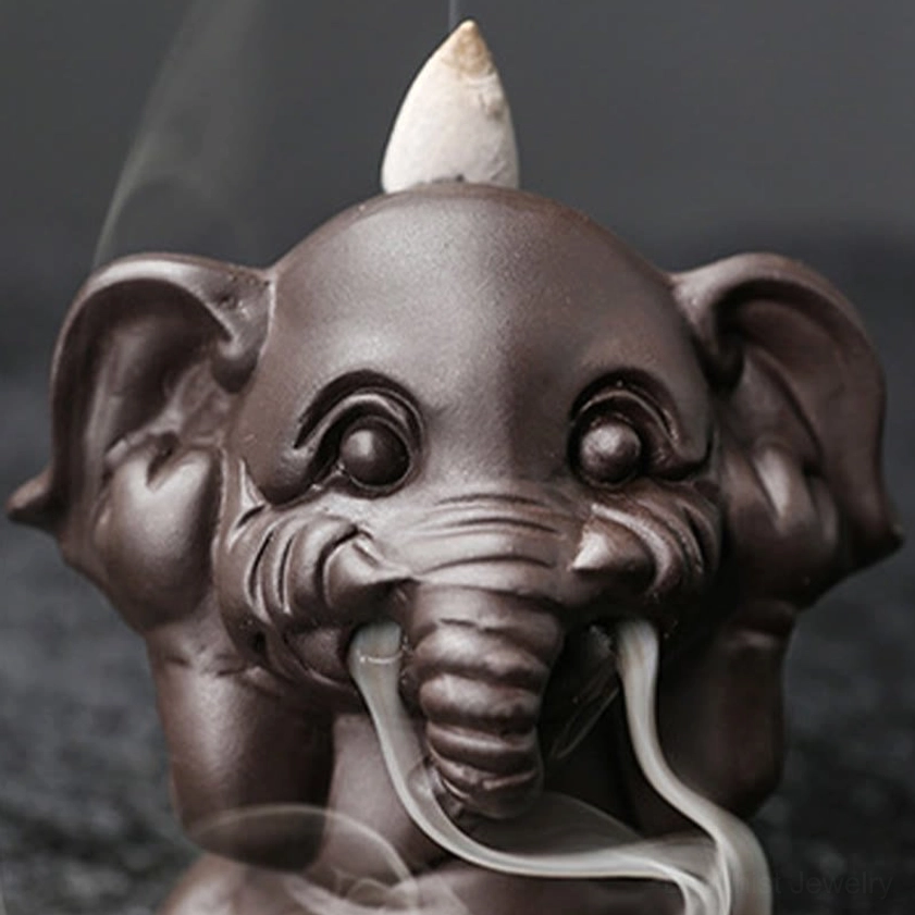 Elephant incense burner with naturally lit backflow incense showing aromatic smoke cascade and therapeutic ambiance