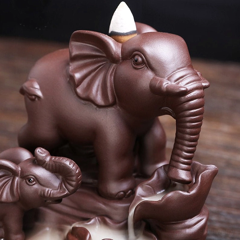 Close-up detail of double elephant incense burner showing facial features and backflow smoke channel