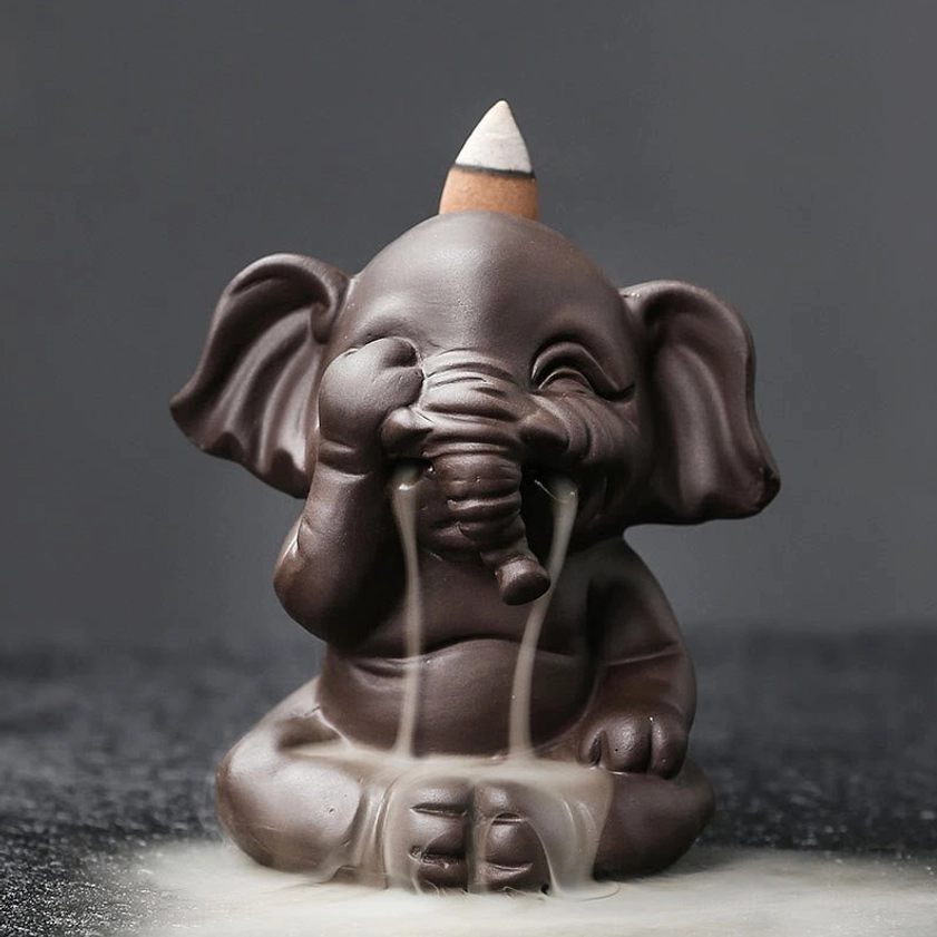 Single handcrafted elephant backflow incense burner with hear-no-evil mudra pose showing cascading smoke from trunk close-up view