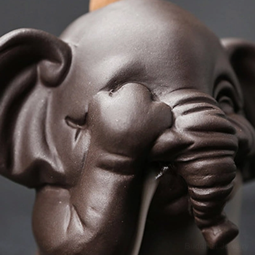Purple clay elephant incense holder with lit incense cone showing authentic backflow smoke effect and fragrance diffusion