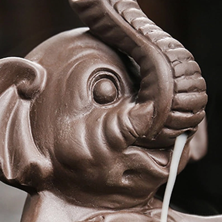 Overhead view of elephant-shaped purple clay backflow incense burner showing full design and smoke effect
