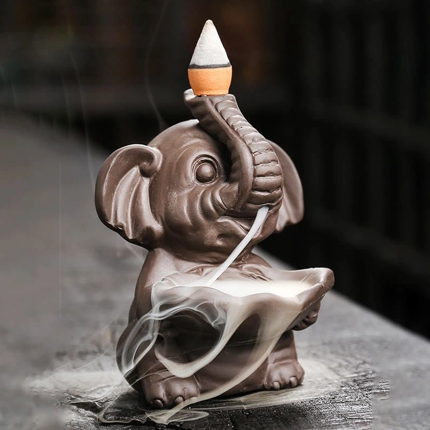 Three-quarter front view of handcrafted purple clay elephant incense fountain with matte finish and active smoke flow