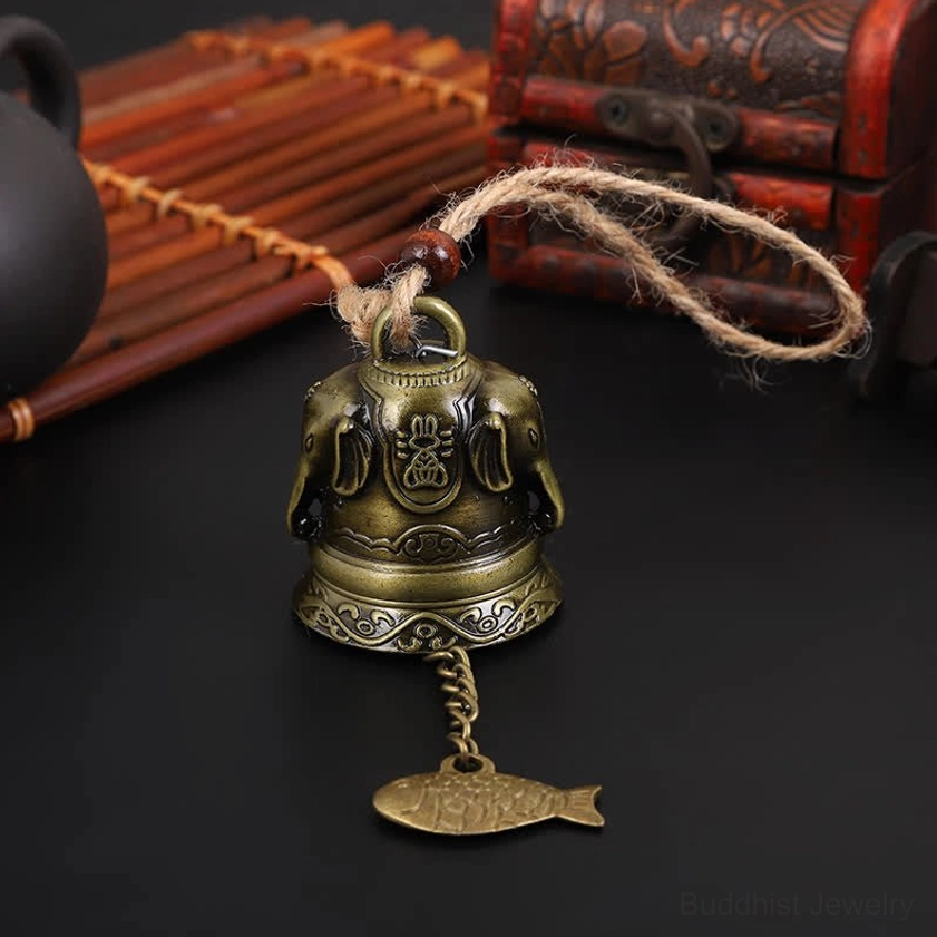 Sacred embossed Buddhist wind chime with elephant and deity patterns on Chinese style desktop