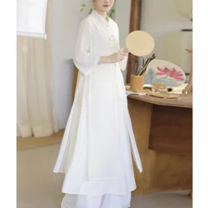 White embroidered chiffon meditation dress with stand collar and three-quarter sleeves, left side three-quarter view showcasing flowing silhouette and delicate embroidered chest detail