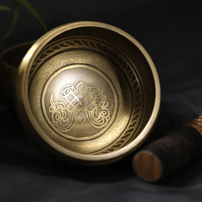 Overhead view of Buddhist singing bowl showing endless knot and decorative rim engraving