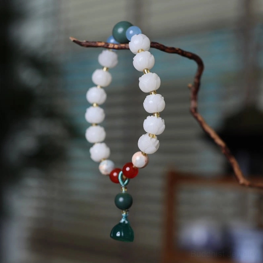 Delicate Buddhist bracelet with bodhi seeds and green lotus pod pendant hanging on natural wood