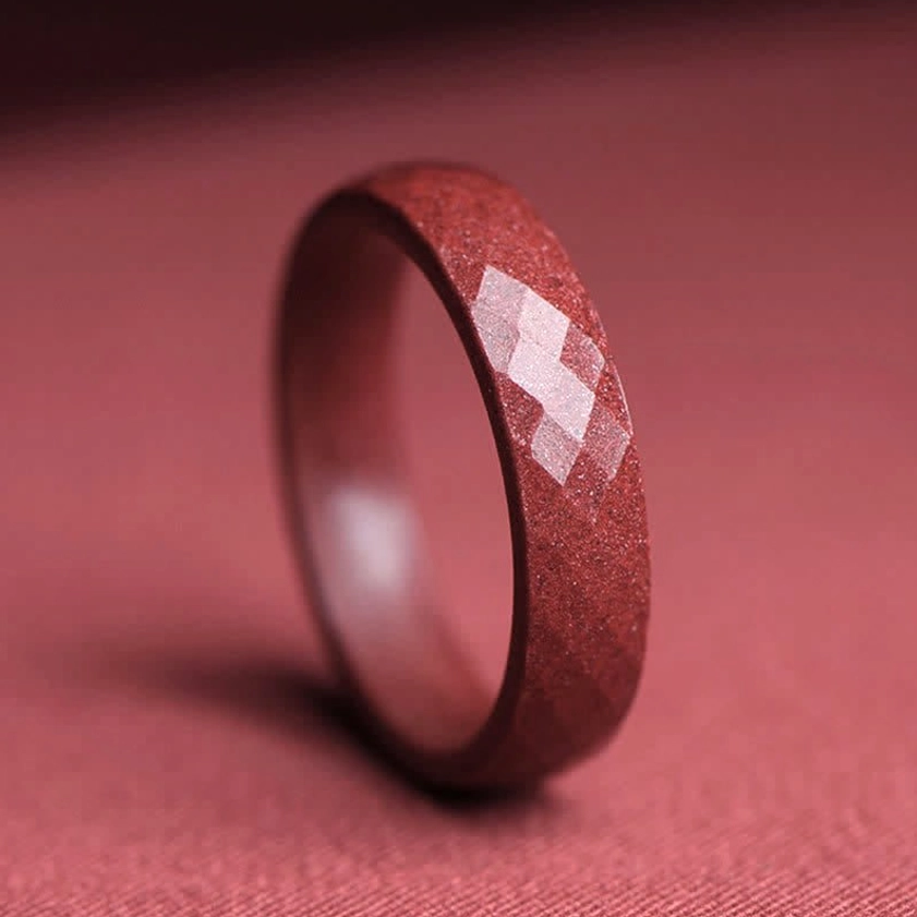Side view of faceted cinnabar ring showing diamond-cut surface with sparkly mineral texture and Buddhist spiritual craftsmanship
