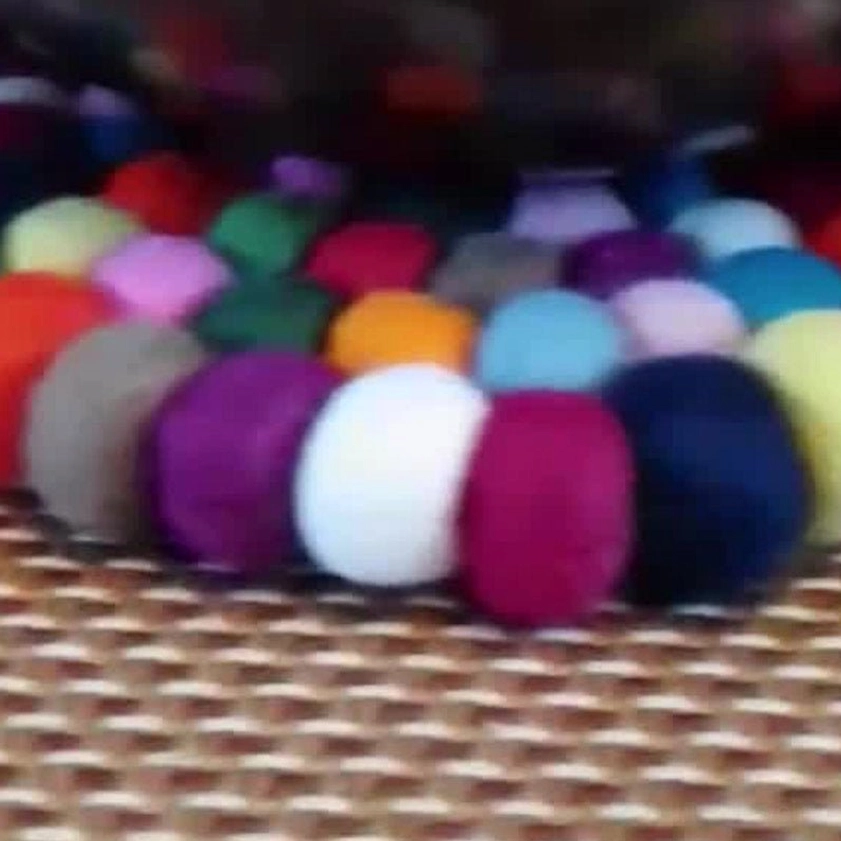 Macro close-up of multicolor felted wool pom-pom strips arranged in striped pattern