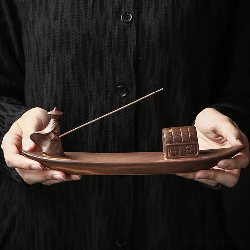 Person holding handmade fisherman boat incense holder, demonstrating size and craftsmanship detail