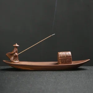 Handcrafted fisherman boat ceramic incense burner with rising incense smoke, vintage brown finish, left side view