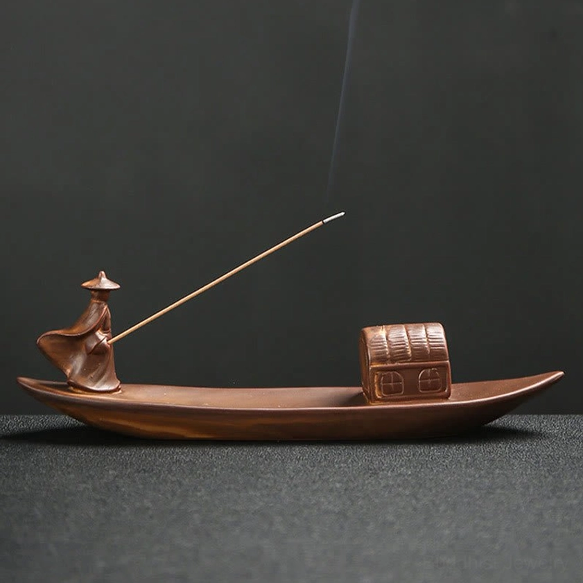 Handcrafted fisherman boat ceramic incense burner with rising incense smoke, vintage brown finish, left side view
