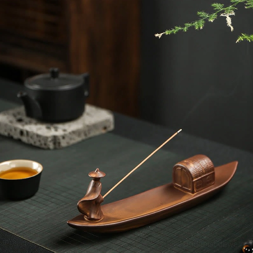 Buddhist incense burner in tea table setting with tea set, creating mindful atmosphere