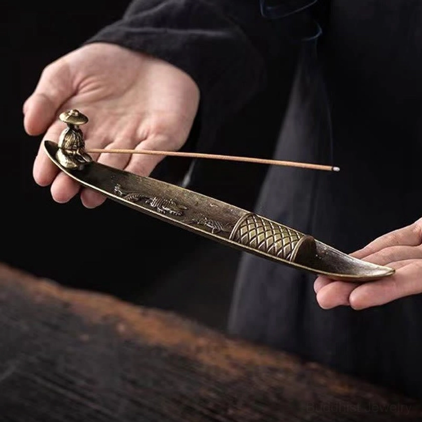 Fisherman boat incense holder held by two hands, cast zinc alloy with fisherman figurine and incense stick