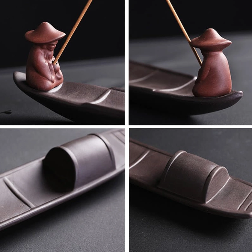 Close-up of traditional fisherman figurine wearing conical straw hat on purple clay incense burner, detail shot of artisan hand-sculpted design