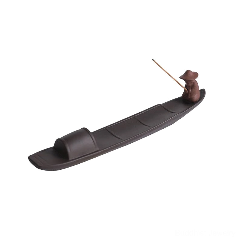 Rear view of fisherman figure on Buddhist incense holder, showing conical hat detail and incense stick placement on boat deck for spiritual practice