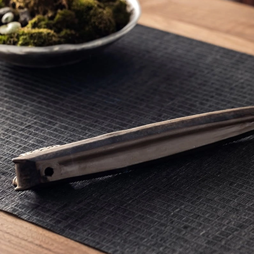Side profile showing pointed boat end and incense slot of handmade ceramic Buddhist incense holder