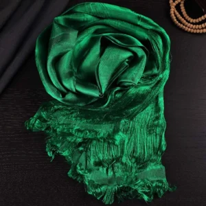 Deep green five-color Buddhist blessing khata scarf with jacquard weave and frayed tassels, displayed on dark wooden surface with meditation prayer beads