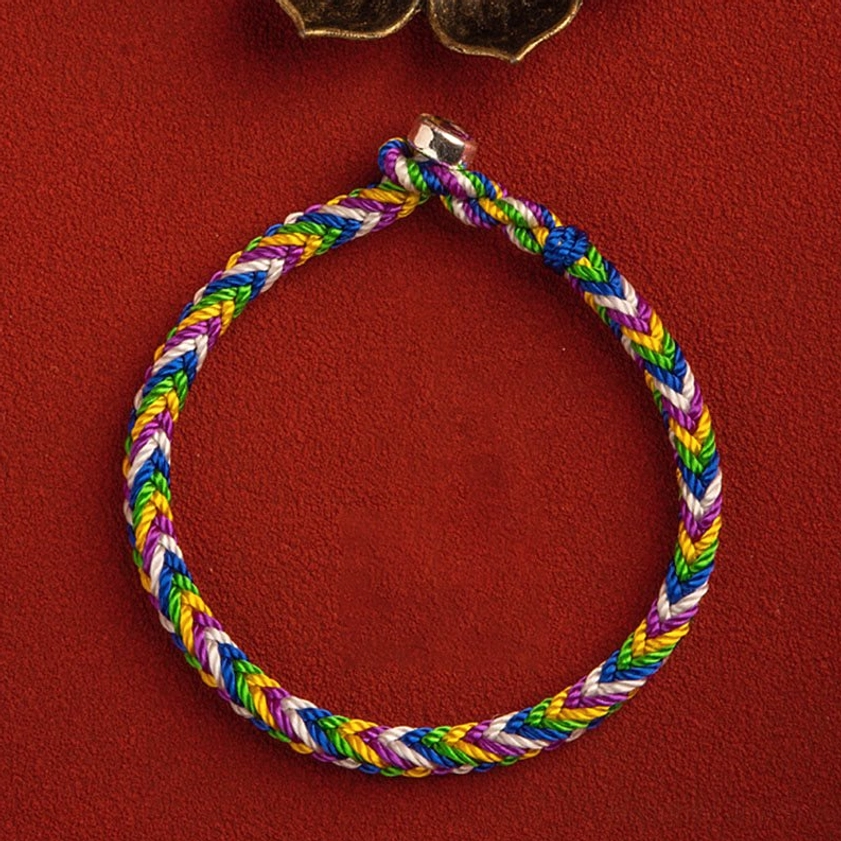 Five-color Buddhist bracelet with silver clasp showing craftsmanship detail and rainbow thread weave