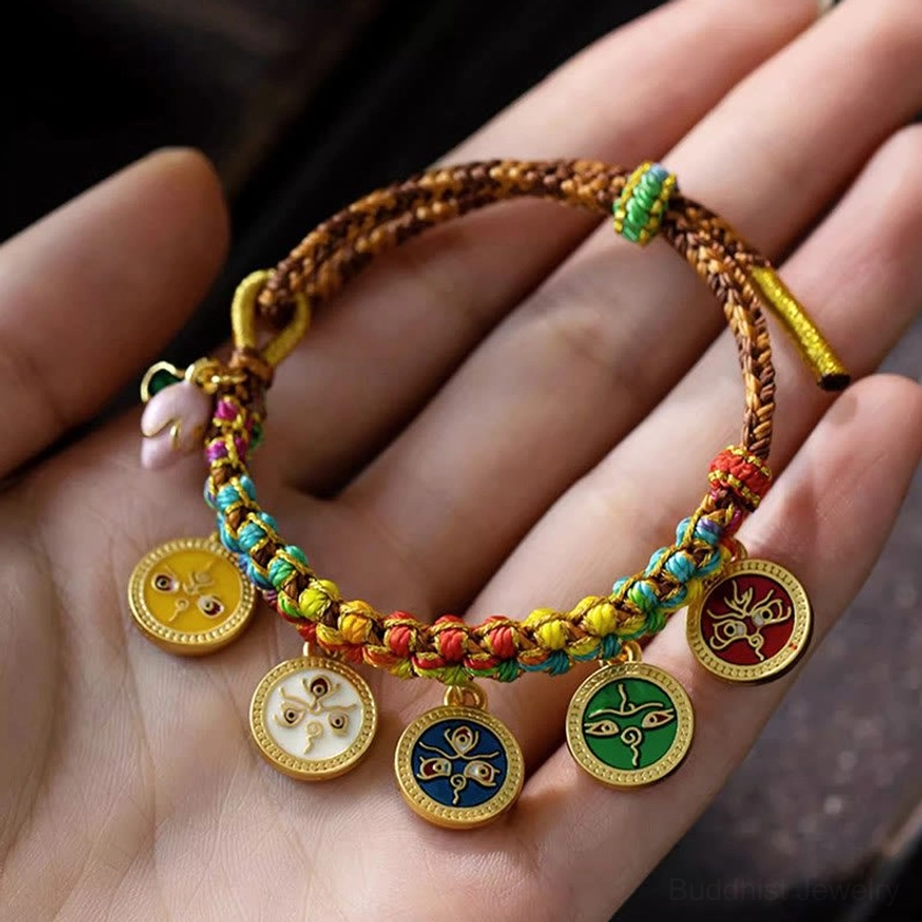 Detailed macro view of Five Gods of Wealth enamel pendants on braided Buddhist bracelet, showcasing five distinct deity symbols and cord craftsmanship